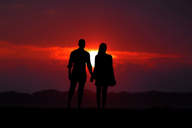 Silhueta de um casal de mãos dadas no pôr do sol