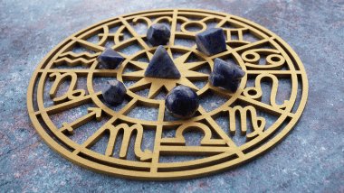 Há uma Roda do Zodíaco com os símbolos dos signos em volta. Em cima, há algumas pedras.