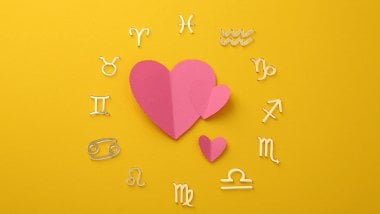 Há uma Roda do Zodíaco com os símbolos dos signos em volta. No meio, há três corações.