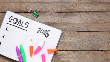 Imagem de um caderno com as metas para o ano de 2026, além de canetas coloridas para identificar as prioridades.