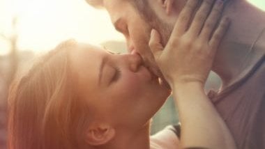 Imagem de um casal se beijando e ao fundo um lindo pôr do Sol.