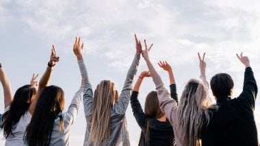 Imagem de várias pessoas, mulheres e homens com as mãos levantadas para o céu, simbolizando que estão no caminho certo e vivendo o momento para a evolução interior.