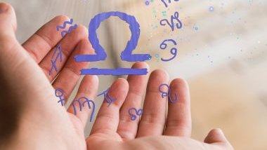 Imagem da mão de uma mulher, segurando os glifos dos 12 signos do zodíaco que estão na cor lilás. Em destaque, o glifo do signo de libra.