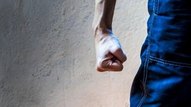 Imagem do braço de um homem, com uma das mãos fechadas, simbolizando uma agressão física.