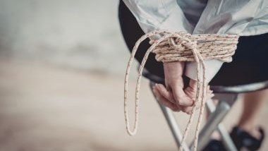 Imagem de uma pessoa sentada e amarrada em uma cadeira, simbolizando um sequestro.