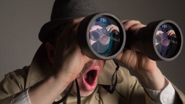 Imagem de um homem usando um binóculo simbolizando que está perseguindo uma pessoa.