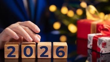 Imagem do ano de 2026 feito em quadradinhos de madeira e a mão de uma mulher manipulando os dados.