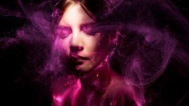 Imagem do rosto de uma mulher com efeitos de luz na cor roxa, simbolizando a pombagira Dama da Noite.