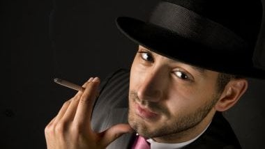 Imagem do rosto de um homem malandro, usando um chapéu preto e fumando um cigarro, simbolizando a entidade Zé Malandro na Umbanda.