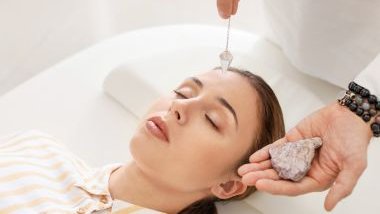 Imagem de uma mulher deitada sobre uma maca, recebendo uma sessão de reiki com uso de pedras e cristais.