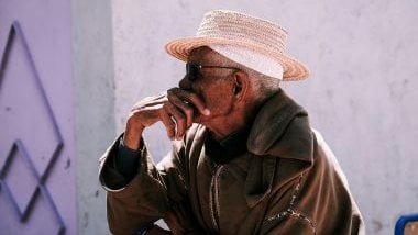 Imagem de um idoso negro, usando um chapéu branco, simbolizando o Pai João na Umbanda.