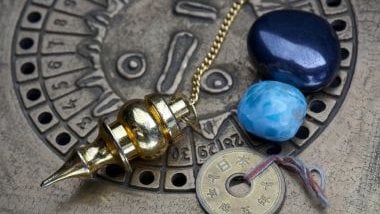 Imagem de uma mandala astrológica com cristais na cor azul sobre ela.