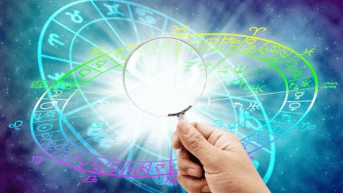 Uma mão segura uma lupa e, atrás dela, há duas Rodas do Zodíaco no conceito universo.