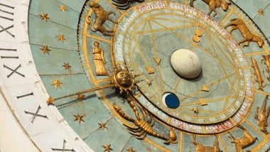 A imagem foca em algumas partes de um relógio astrológico.