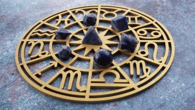 Há uma Roda do Zodíaco com os símbolos dos signos em volta. Em cima, há algumas pedras.