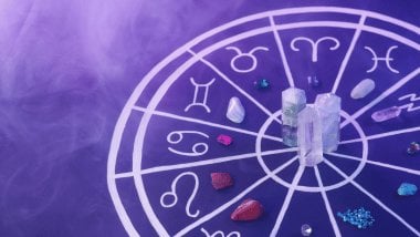 No foco da imagem, há uma Roda do Zodíaco com os símbolos dos signos e há cristais em cima dela.