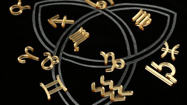 Os símbolos dos signos do zodíaco estão espalhados sobre uma superfície na cor preta.