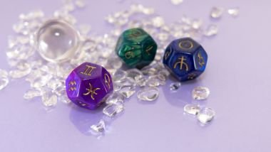 Imagem de três cristais nas cores azul, verde e roxo e cada um deles traz os glifos dos signos.