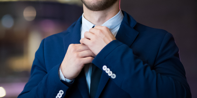 Homem de terno azul ajustando sua gravata