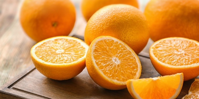 Foto de laranjas inteiras e cortadas ao meio