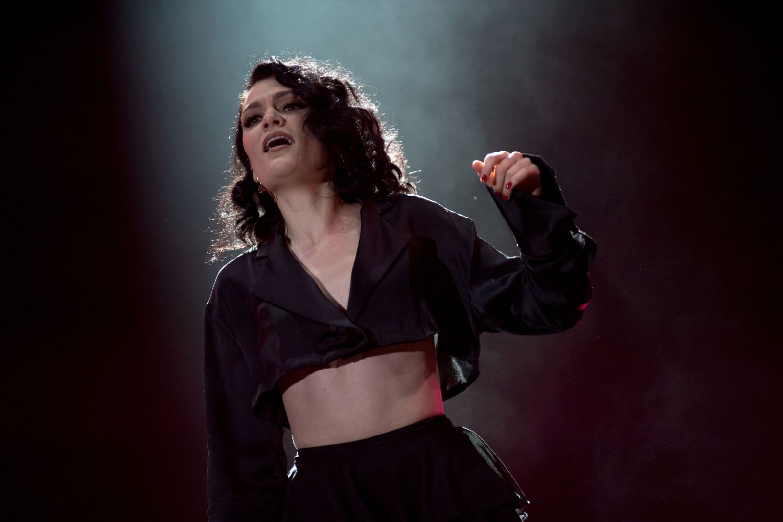 Jessie J cantando no palco com fumaça em sua volta