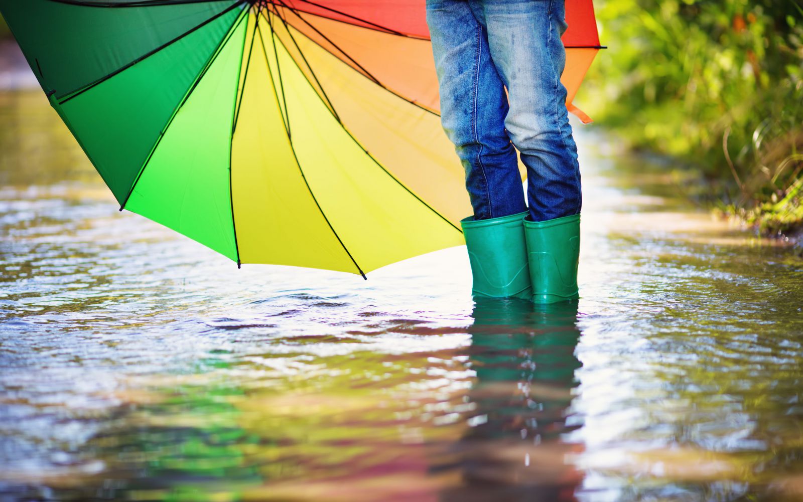 Pessoa andando em uma enchente segurando guarda-chuva