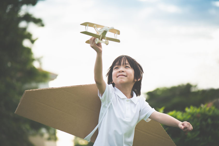 Criança brincando com avião de brinquedo 