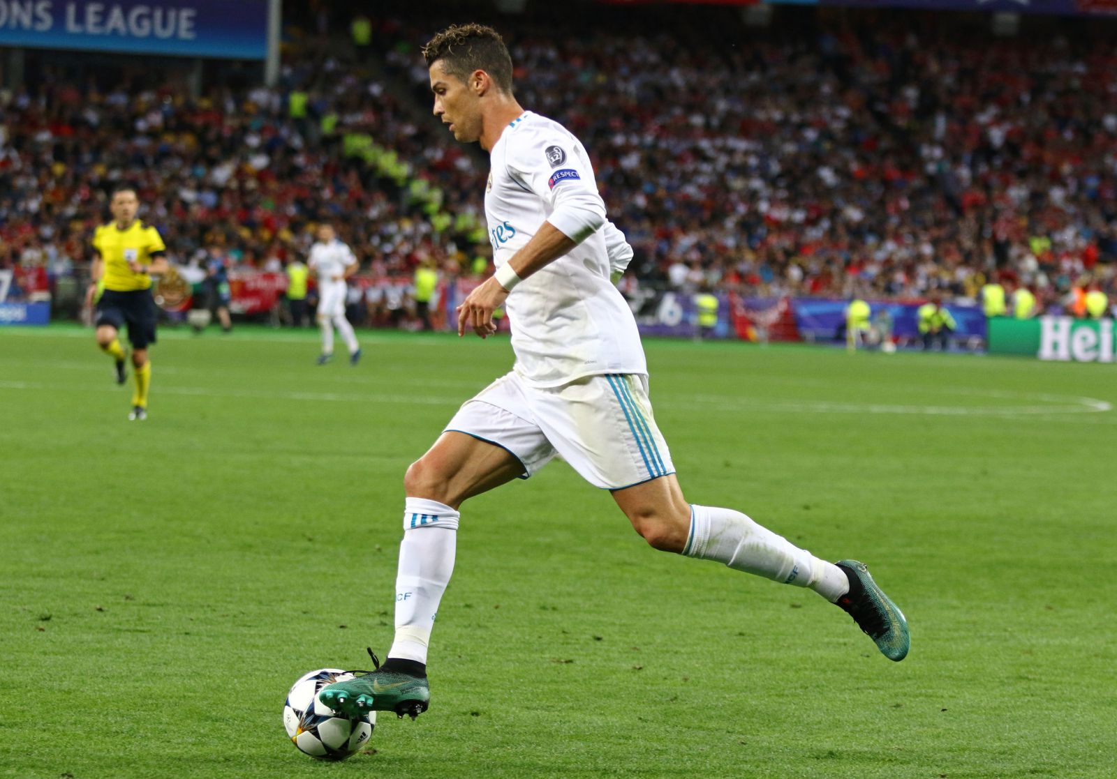 Cristiano Ronaldo correndo no campo de futebol com a bola em seu pé