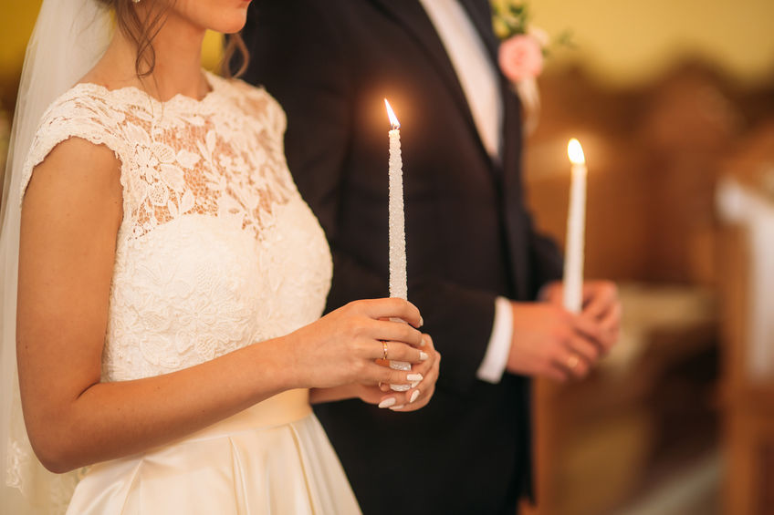 Casal em altar segurando velas