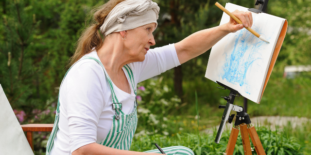 Mulher idosa pintando quadro 