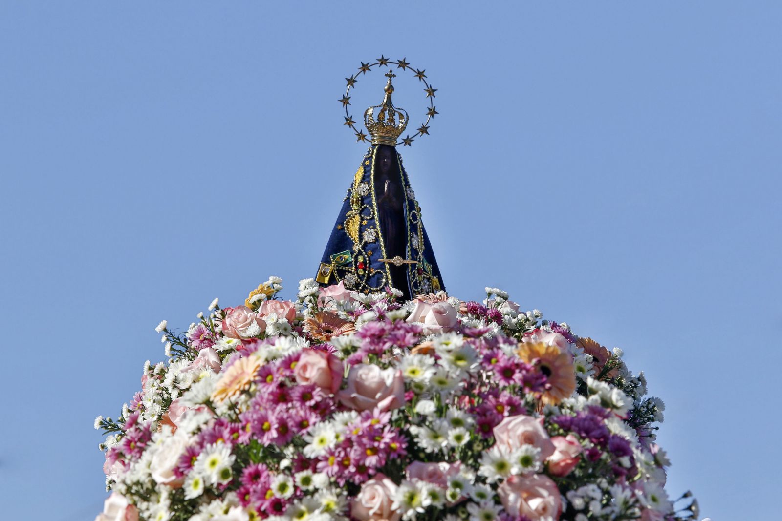 Estátua da Nossa Senhora Aparecida decorada com flores ao redor