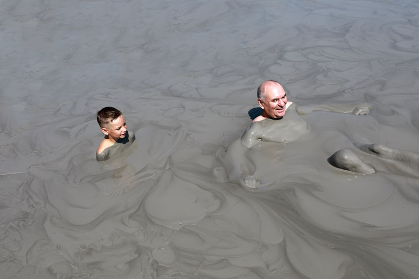 Pai e filho em banho de lama