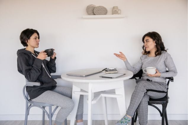 duas amigas conversando enquanto tomam café