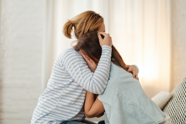 Mulher consolando outra mulher que chora em seus braços