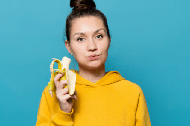 Mulher comendo uma banana madura
