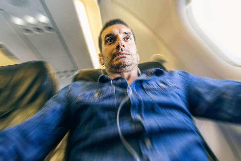 Homem em avião com expressão de pânico