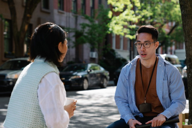 Homem e mulher sentados na rua conversando