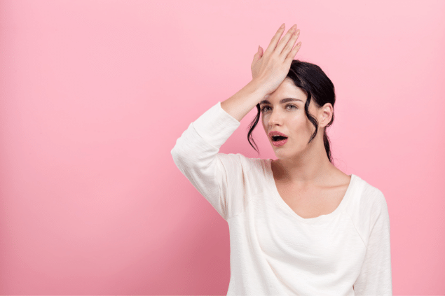 Mulher com expressão surpresa com a mão na testa