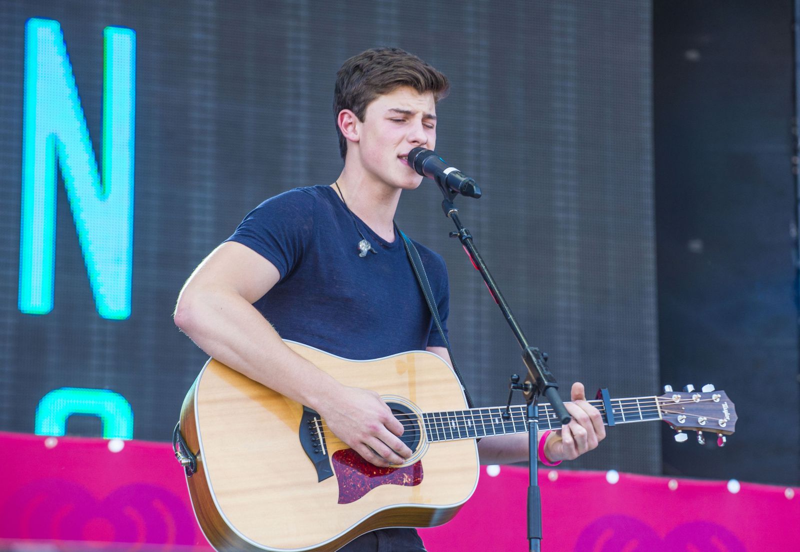 123RF/ Kobby Dagan Shawn Mendes tocando violão e cantando no palco