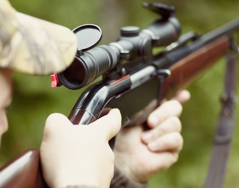 Homem mirando rifle de caça