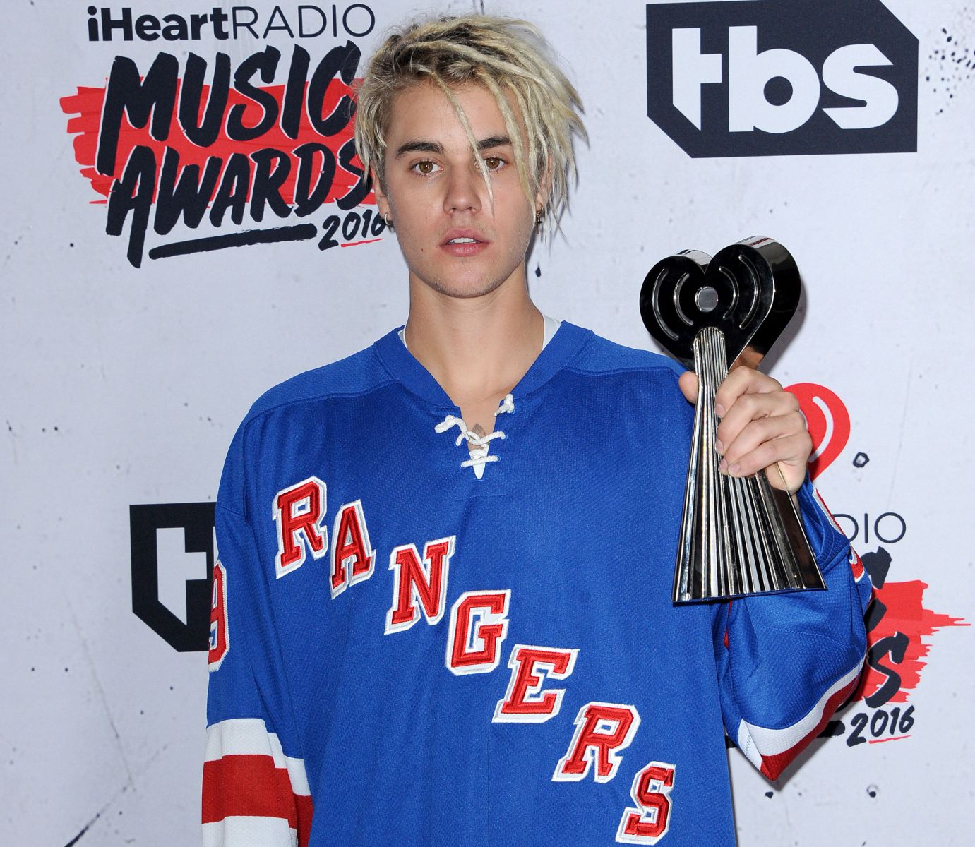 Justin Bieber em uma premiação de música segurando seu prêmio 