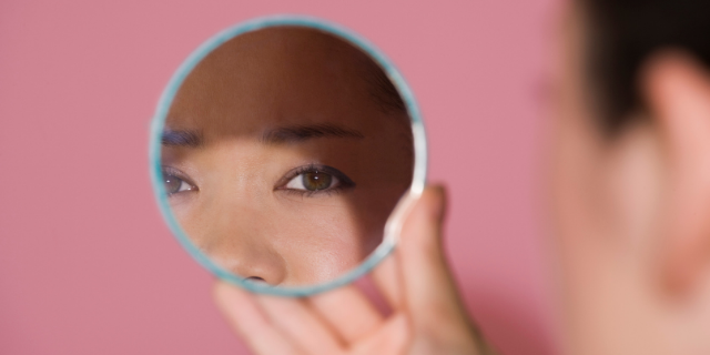 Reflexo dos olhos de uma mulher no espelho