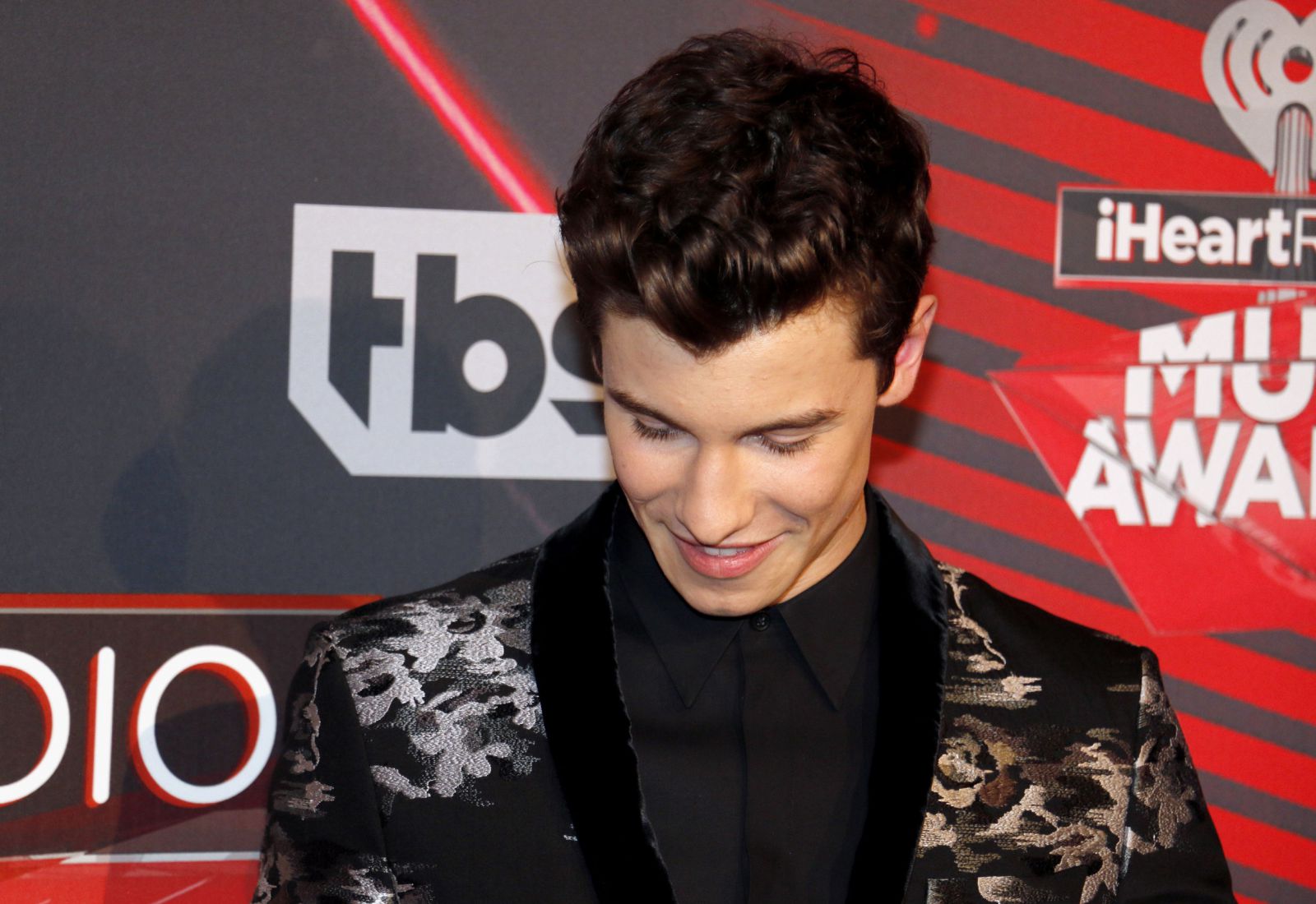 132RF/buzzfuss Shawn Mendes em premiação olhando para baixo e sorrindo