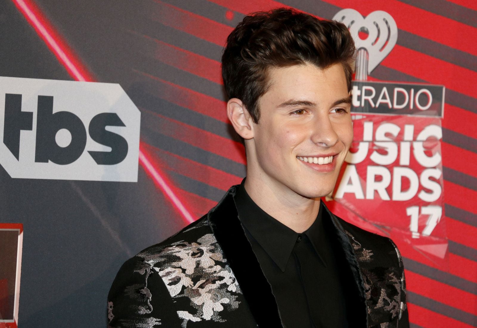 Shawn Mendes olhando para frente e sorrindo em premiação