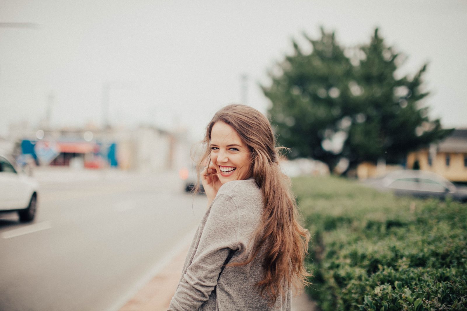 Olivia Paige/Reshot Mulher sorrindo olhando para trás na rua