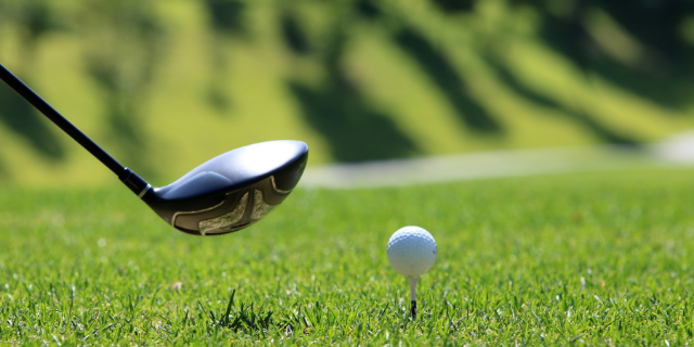 Taco de golfe posicionado na frente da bola de golfe
