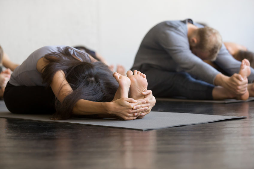 Pessoa com mãos nos pés praticando Yoga