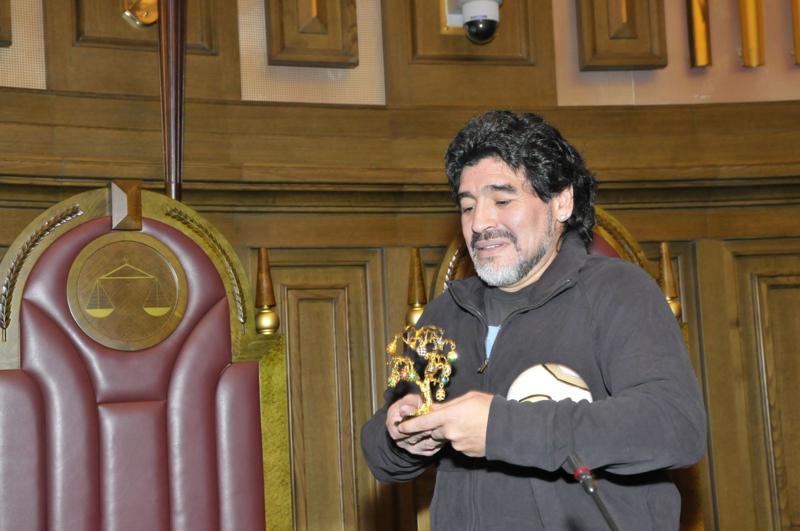 Diego Maradona segurando premio e bola de futebol