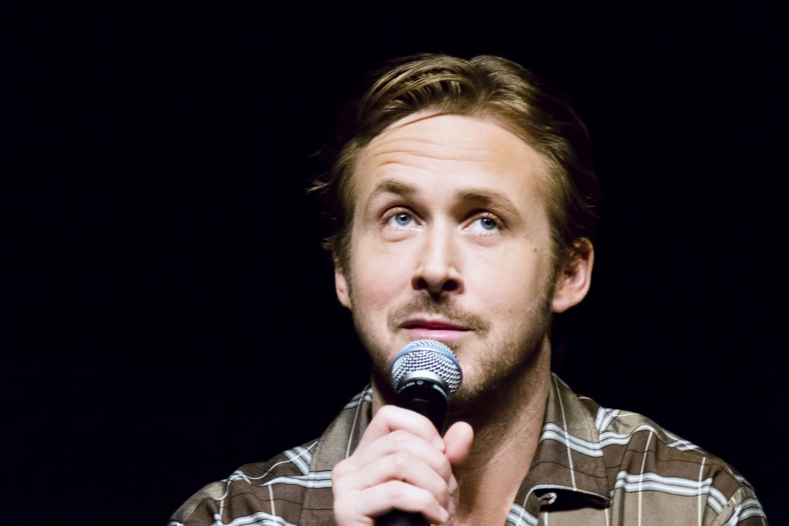 Ryan Gosling falando em um microfone