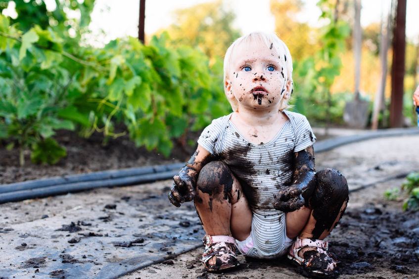 Criança suja de lama